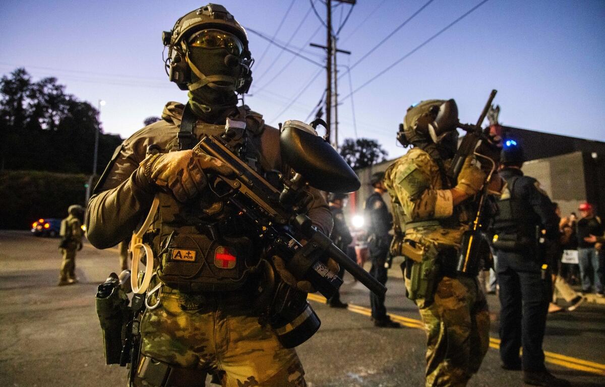 Federal enforcement officers stand guard near a U.S. Immigration and Customs Enforcement facility in Portland, Ore., Monday, Oct. 6, 2025. (AP Photo/Ethan Swope)