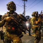 Federal enforcement officers stand guard near a U.S. Immigration and Customs Enforcement facility in Portland, Ore., Monday, Oct. 6, 2025. (AP Photo/Ethan Swope)