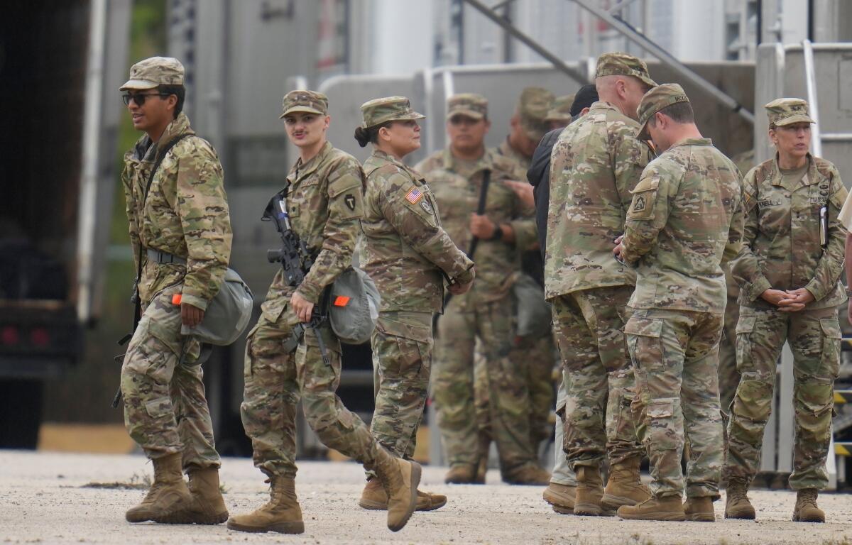 Military personnel in uniform, with the Texas National Guard patch on, are seen at the U.S. Army Reserve Center, Tuesday, Oct. 7, 2025, in Elwood, Ill., a suburb of Chicago. (AP Photo/Erin Hooley)