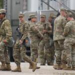 Military personnel in uniform, with the Texas National Guard patch on, are seen at the U.S. Army Reserve Center, Tuesday, Oct. 7, 2025, in Elwood, Ill., a suburb of Chicago. (AP Photo/Erin Hooley)