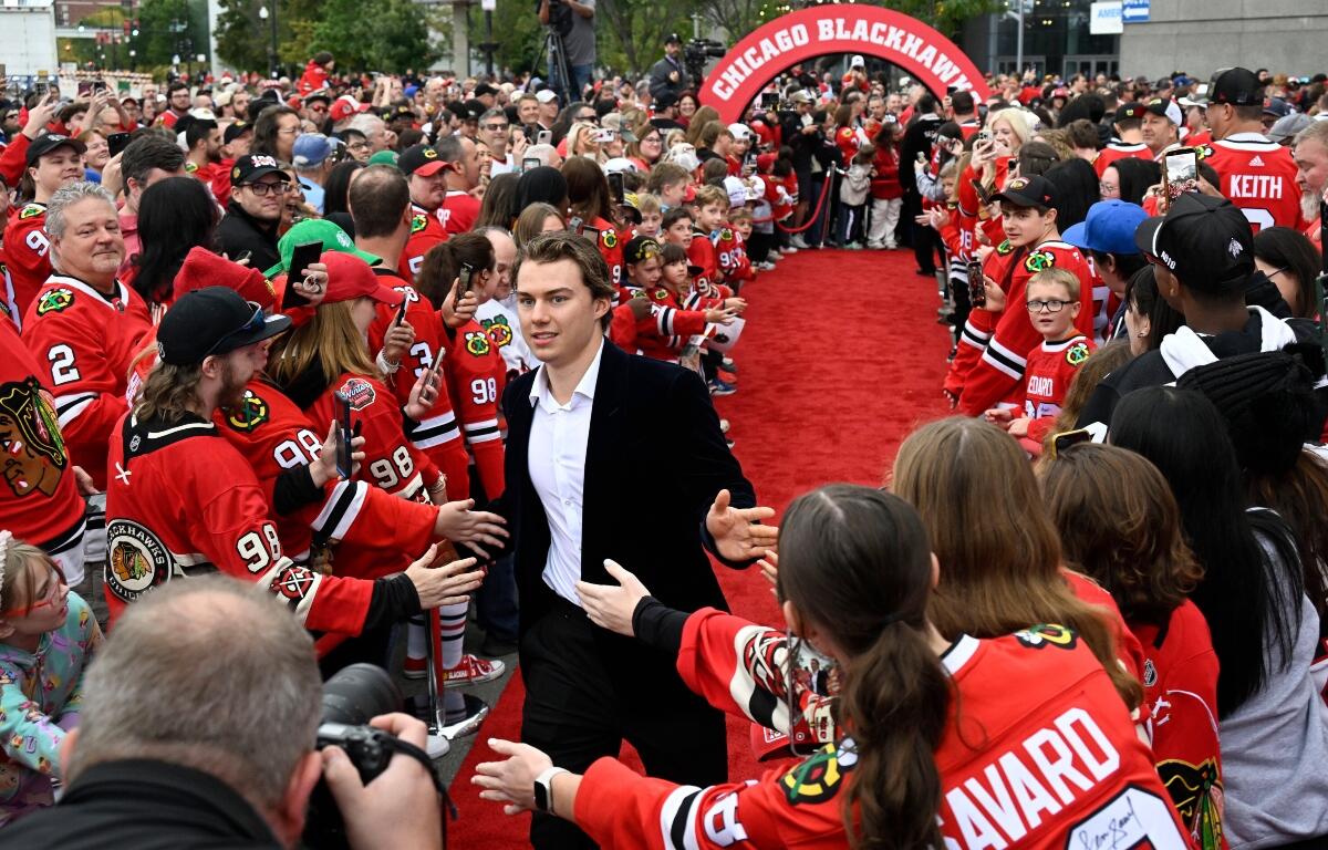 Chicago Blackhawks center Connor Bedard greets fans on a red carpet before an NHL hockey game against the Montreal Canadiens, Saturday, Oct. 11, 2025, in Chicago. (AP Photo/Matt Marton)