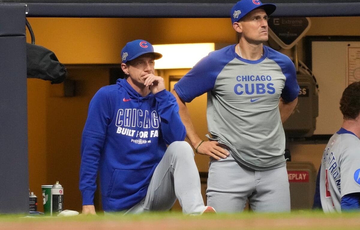 Chicago Cubs manager Craig Counsell, left, and bench coach Ryan Flaherty, right, look on from the dugout during the seventh inning of Game 5 of baseball's National League Division Series against the Milwaukee Brewers, Saturday, Oct. 11, 2025, in Milwaukee.