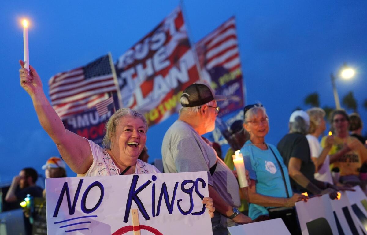 FILE - Dee Cahill of Margate, Fla., holds a "No Kings" sign as she participates in a pro-democracy, anti-Trump protest outside Trump's Mar-a-Lago estate in Palm Beach, Fla., Thursday, July 17, 2025. (AP Photo/Rebecca Blackwell, File)