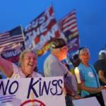 FILE - Dee Cahill of Margate, Fla., holds a "No Kings" sign as she participates in a pro-democracy, anti-Trump protest outside Trump's Mar-a-Lago estate in Palm Beach, Fla., Thursday, July 17, 2025. (AP Photo/Rebecca Blackwell, File)