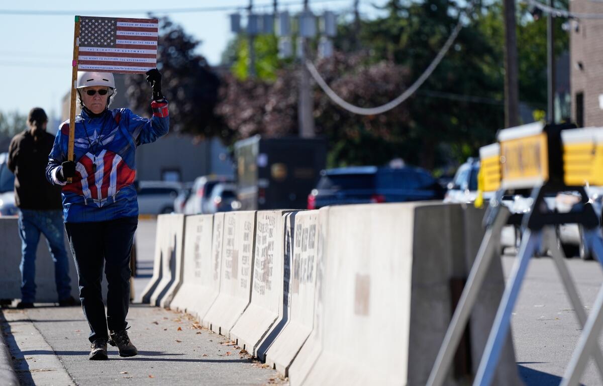 Jeanette Mancusi holds a American flag with the writing outside an ICE (U.S. Immigration and Customs Enforcement) processing facility in the Chicago suburb of Broadview, Ill., Monday, Oct. 20, 2025. (AP Photo/Nam Y. Huh)