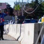 Jeanette Mancusi holds a American flag with the writing outside an ICE (U.S. Immigration and Customs Enforcement) processing facility in the Chicago suburb of Broadview, Ill., Monday, Oct. 20, 2025. (AP Photo/Nam Y. Huh)