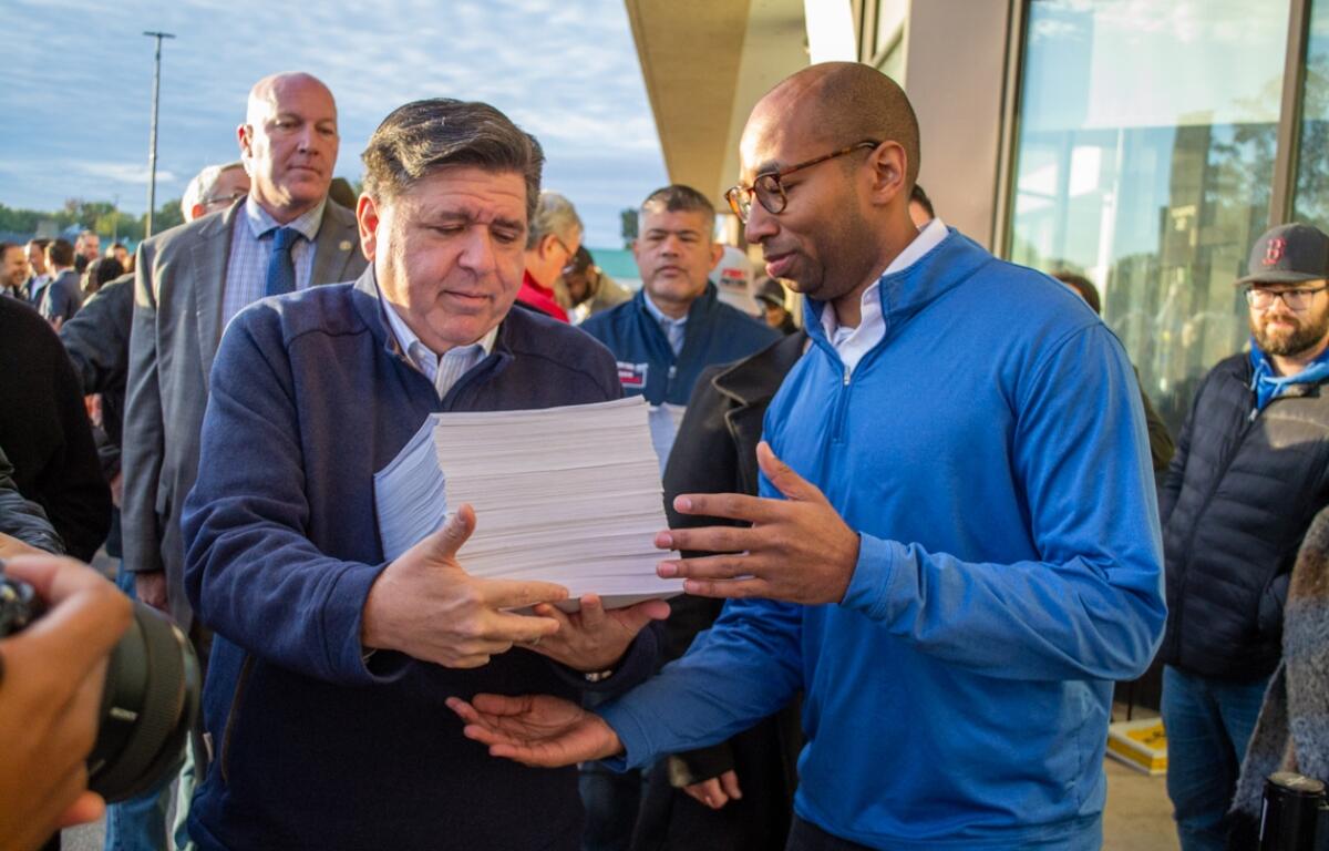 Gov. JB Pritzker and lieutenant governor candidate Christian Mitchell prepare to file nominating petitions at the Illinois State Board of Elections building in Springfield on Monday, Oct. 27. Between them is Cook County Republican Party Chair Aaron Del Mar, who is running for lieutenant governor on the GOP ticket alongside former state Sen. Darren Bailey. (Capitol News Illinois photo by Jerry Nowicki) Gov. JB Pritzker and lieutenant governor candidate Christian Mitchell prepare to file nominating petitions at the Illinois State Board of Elections building in Springfield on Monday, Oct. 27. Between them is Cook County Republican Party Chair Aaron Del Mar, who is running for lieutenant governor on the GOP ticket alongside former state Sen. Darren Bailey. (Capitol News Illinois photo by Jerry Nowicki)
