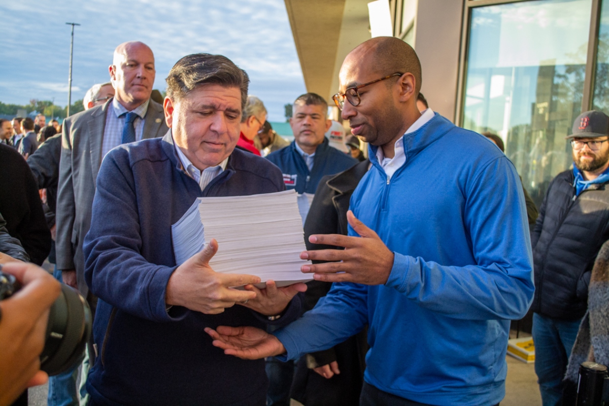 Gov. JB Pritzker and lieutenant governor candidate Christian Mitchell prepare to file nominating petitions at the Illinois State Board of Elections building in Springfield on Monday, Oct. 27. Between them is Cook County Republican Party Chair Aaron Del Mar, who is running for lieutenant governor on the GOP ticket alongside former state Sen. Darren Bailey. (Capitol News Illinois photo by Jerry Nowicki) Gov. JB Pritzker and lieutenant governor candidate Christian Mitchell prepare to file nominating petitions at the Illinois State Board of Elections building in Springfield on Monday, Oct. 27. Between them is Cook County Republican Party Chair Aaron Del Mar, who is running for lieutenant governor on the GOP ticket alongside former state Sen. Darren Bailey. (Capitol News Illinois photo by Jerry Nowicki)