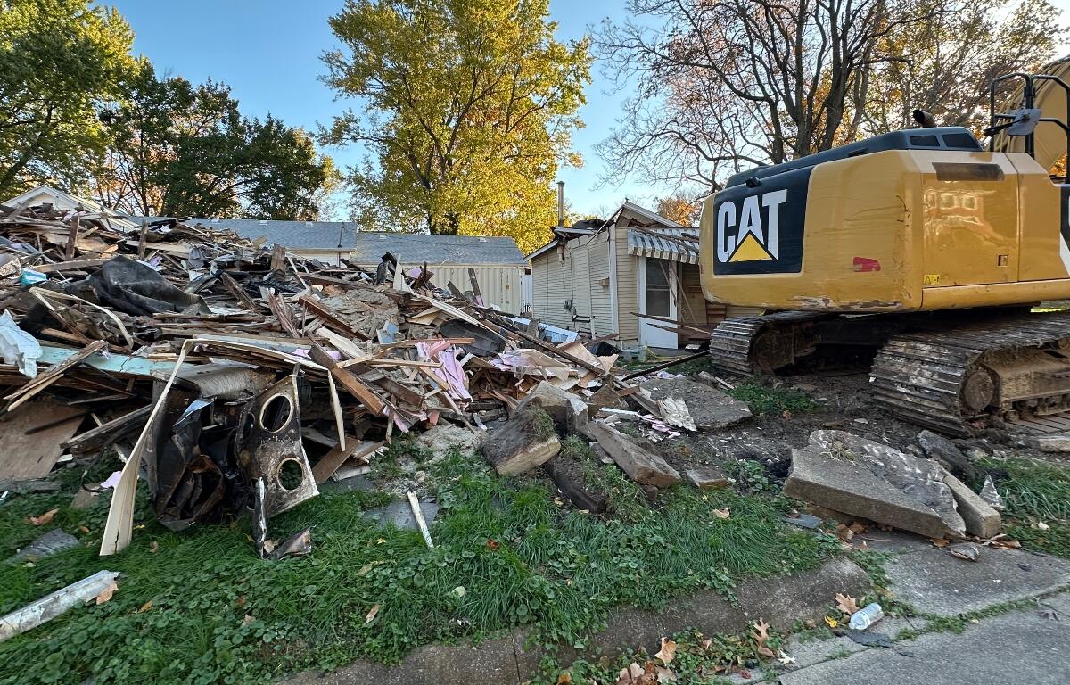 The house on right, behind the excavator, was hit by the excavator Tuesday evening.