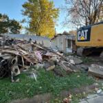 The house on right, behind the excavator, was hit by the excavator Tuesday evening.