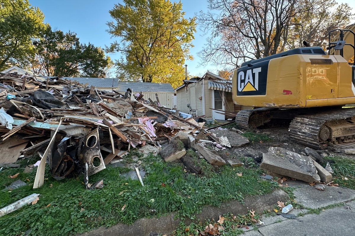 The house on right, behind the excavator, was hit by the excavator Tuesday evening.