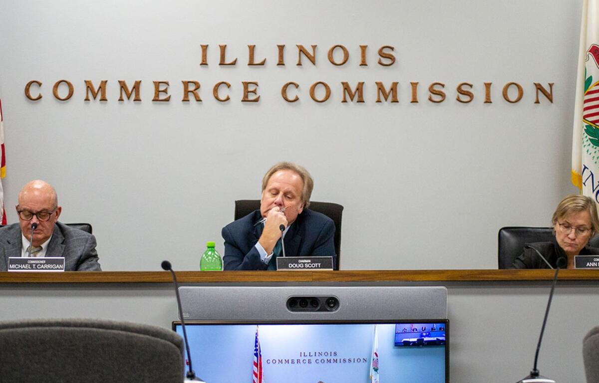 llinois Commerce Commission Chair Dough Scott is pictured alongside commissioners Michael Carrigan (left) and Ann McCabe (right) at a November 2023 meeting in Springfield. (Capitol News Illinois photo by Jerry Nowicki)