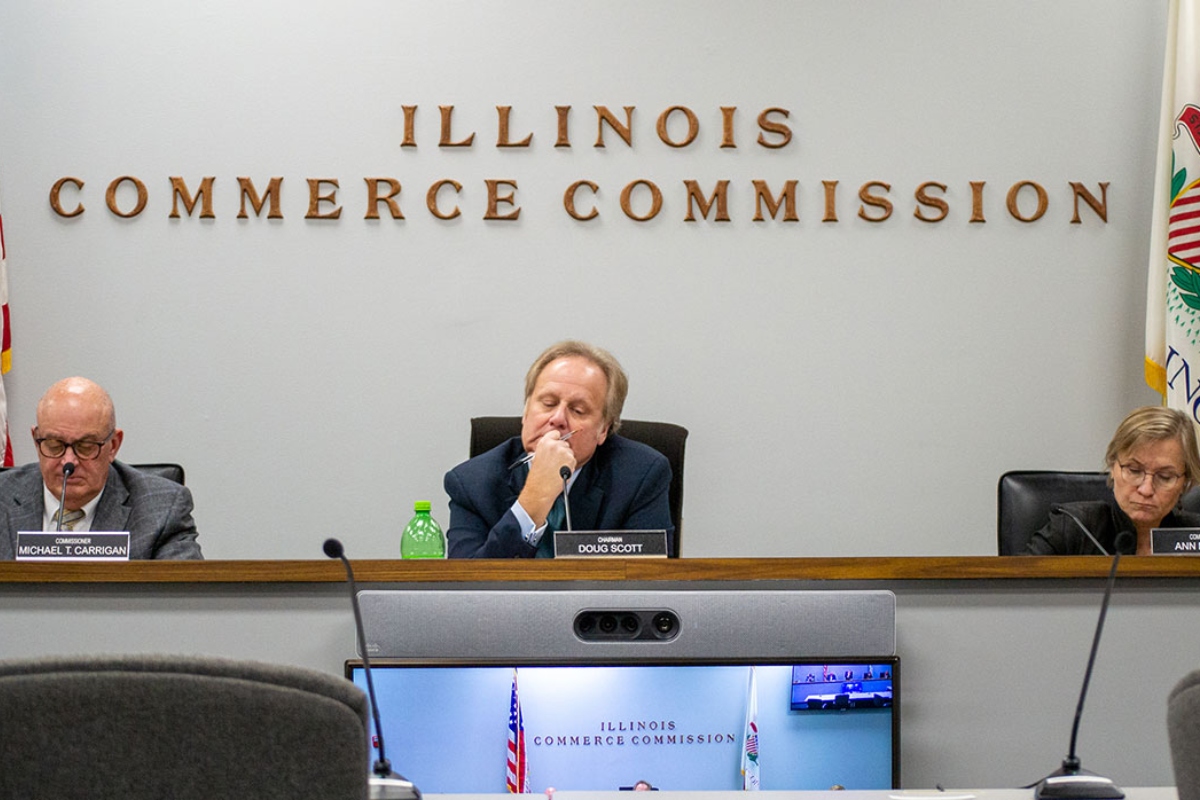 llinois Commerce Commission Chair Dough Scott is pictured alongside commissioners Michael Carrigan (left) and Ann McCabe (right) at a November 2023 meeting in Springfield. (Capitol News Illinois photo by Jerry Nowicki)