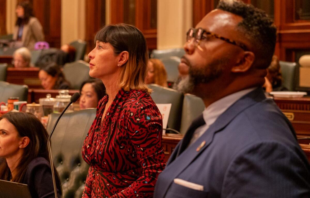 Reps. Eva-Dina Delgado and Kam Buckner watch the House of Representatives discuss their proposal to reform Chicagoland public transit. The two Chicago Democrats led a House working group tasked with overseeing negotiations. (Capitol News Illinois photo by Andrew Adams)