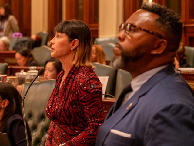 Reps. Eva-Dina Delgado and Kam Buckner watch the House of Representatives discuss their proposal to reform Chicagoland public transit. The two Chicago Democrats led a House working group tasked with overseeing negotiations. (Capitol News Illinois photo by Andrew Adams)