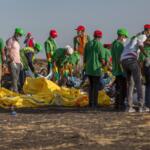 FILE - Workers collect debris on March 12, 2019 at the scene where an Ethiopian Airlines Boeing 737 Max 8 crashed shortly after takeoff, killing all 157 on board, near Bishoftu, or Debre Zeit, south of Addis Ababa, in Ethiopia. (AP Photo/Mulugeta Ayene, File)