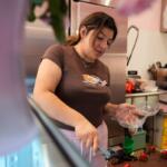 Andrea Melendez cuts a piece of cake for a customer at Pink Flores Bakery and Cafe, Wednesday, Nov. 19, 2025, in the Pilsen neighborhood of Chicago. (AP Photo/Erin Hooley)