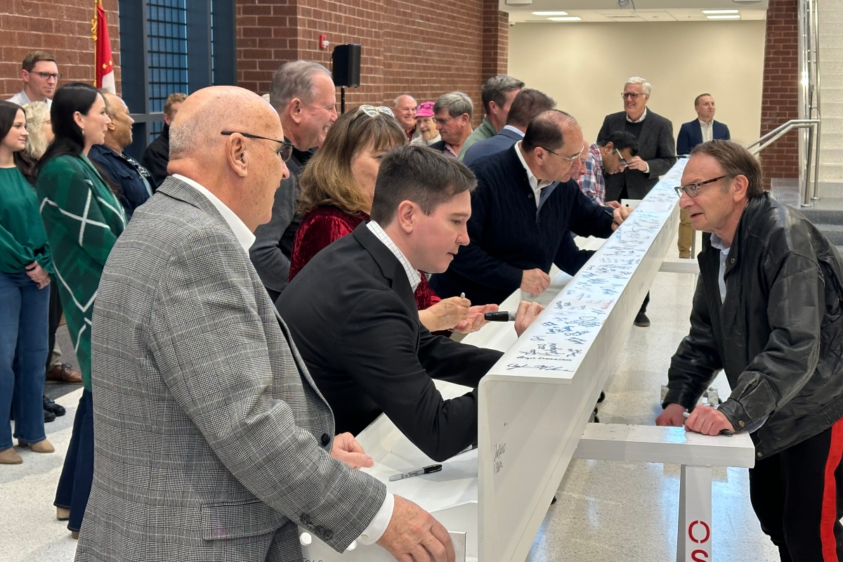 Lawmakers and Sangamon County Board members, among others, sign a beam that will be put up in the new, under-construction, Sangamon County Transportation Center.