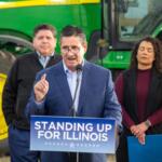 Jerry Costello II, director of the Illinois Department of Agriculture, speaks at a Christian County farm alongside Gov. JB Pritzker (left) and Cameron Joost, assistant director of the Illinois Department of Commerce and Economic Opportunity. The group discussed the impact of tariffs on Illinois farmers in an October visit. (Capitol News Illinois photo by Jerry Nowicki)