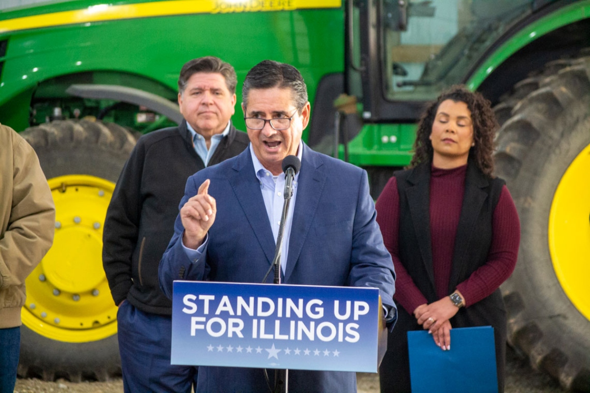 Jerry Costello II, director of the Illinois Department of Agriculture, speaks at a Christian County farm alongside Gov. JB Pritzker (left) and Cameron Joost, assistant director of the Illinois Department of Commerce and Economic Opportunity. The group discussed the impact of tariffs on Illinois farmers in an October visit. (Capitol News Illinois photo by Jerry Nowicki)