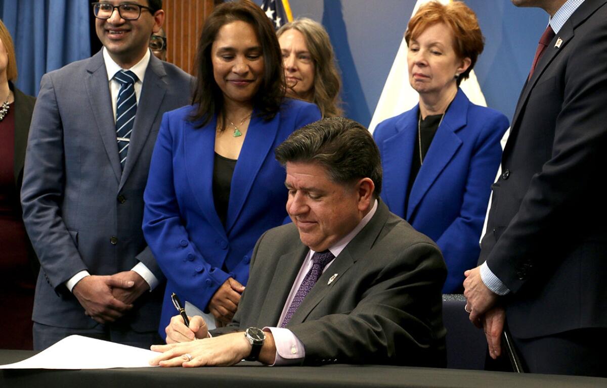 Gov. JB Pritzker signs House Bill 767 at a Dec. 2 news conference in Chicago. He said the bill will protect Illinoisians using science-backed guidelines, rather than “junk science” used by the federal administration under the guidance of Health and Human Services Secretary Robert F. Kennedy Jr. (CNI photo by Maggie Dougherty)