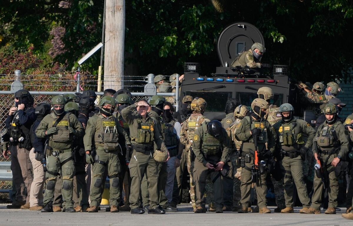 FILE - Greg Bovino, the chief patrol agent for the U.S. Border Patrol El Centro sector, center, stands with federal immigration agents near an Immigration and Customs Enforcement facility in Broadview, Ill., Oct. 3, 2025. (AP Photo/Erin Hooley, File)