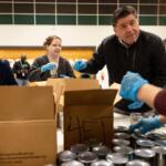 Gov. JB Pritzker packs boxes of canned goods with members of his staff while volunteering Thursday, Dec. 4, 2025, at the Greater Chicago Food Depository. (Brian Cassellav /Chicago Tribune via AP, Pool)