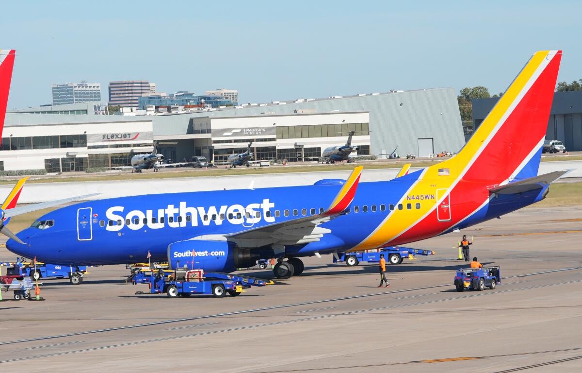 FILE - A Southwest Airlines jet pulls into a gate at Dallas Love Field Airport Tuesday, Nov. 11, 2025, in Dallas. (AP Photo/LM Otero, File)