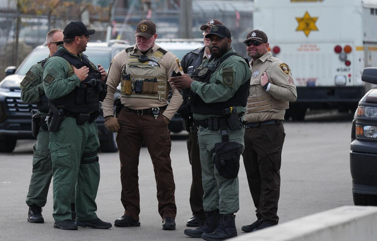 FILE - Law enforcement officers guard outside an ICE processing facility in the Chicago suburb of Broadview, Ill., on Nov. 21, 2025. (AP Photo/Nam Y. Huh, File)