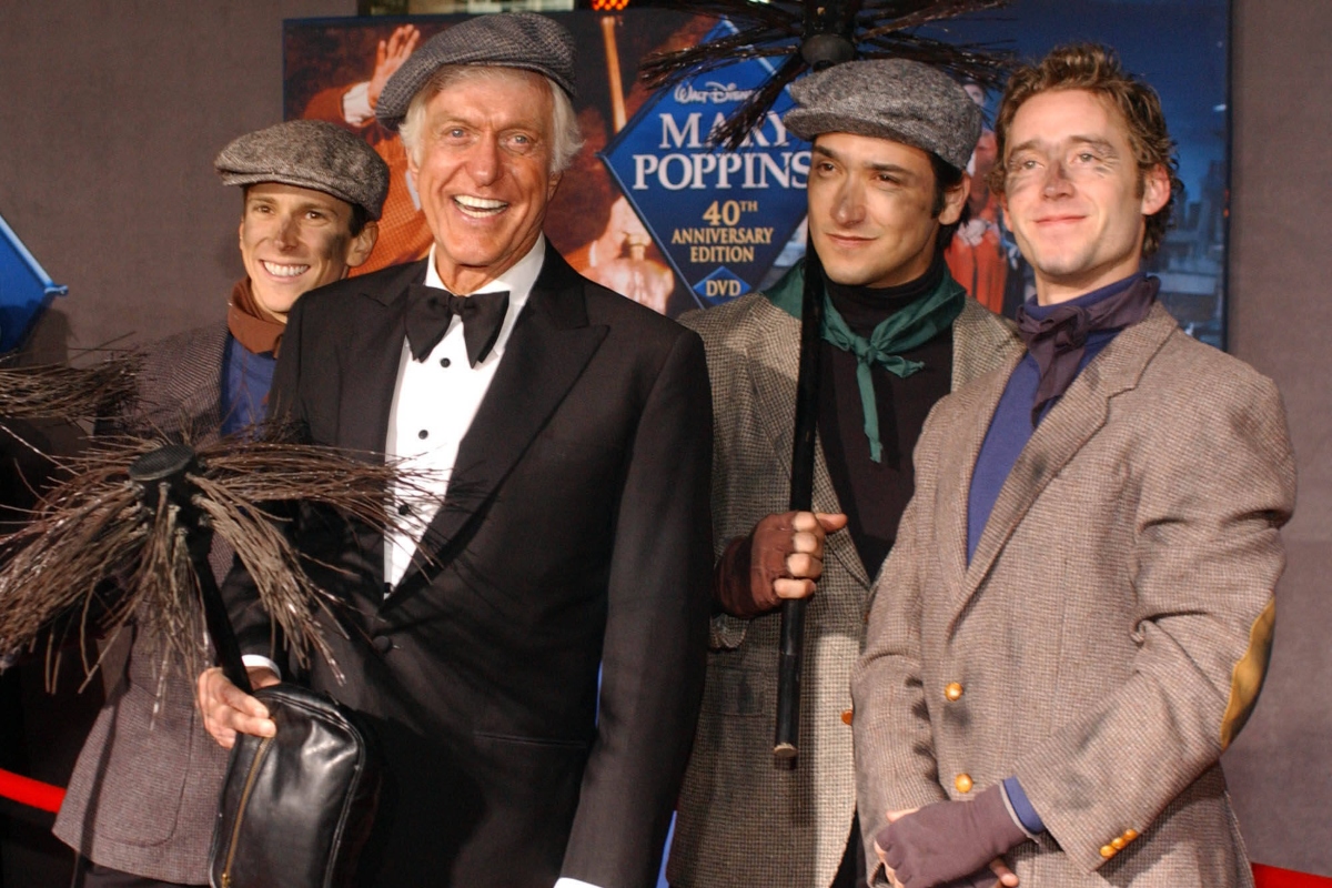 FILE - Dick Van Dyke poses with chimney sweeps during arrivals to the 40th anniversary and re-premiere of Mary Poppins at the El Capitan Theatre in Los Angeles, Tuesday, Nov. 30, 2004. (AP Photo/Ann Johansson, File)