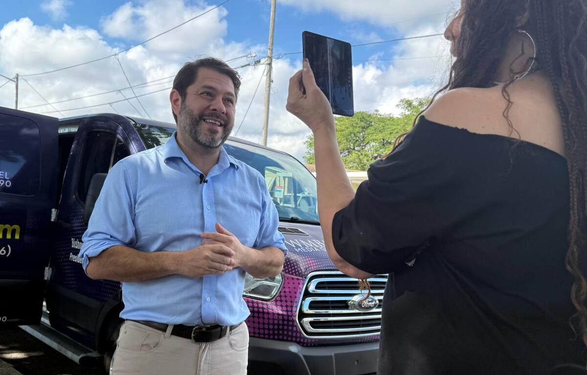 Senator Ruben Gallego, has his photo taken while he campaigns with Eileen Higgins during her campaign for Miami Mayor on Sunday, Dec. 7, 2025 in Miami. (AP Photo/Adriana Gomez)