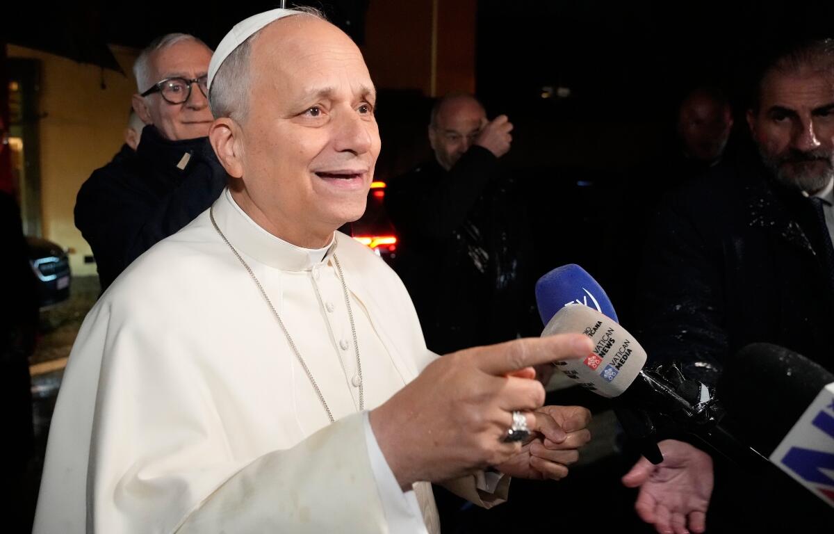 Pope Leo XIV talks to journalists as he leaves the Castel Gandolfo residence to head to the Vatican, Tuesday, Dec. 23, 2025. (AP Photo/Gregorio Borgia)