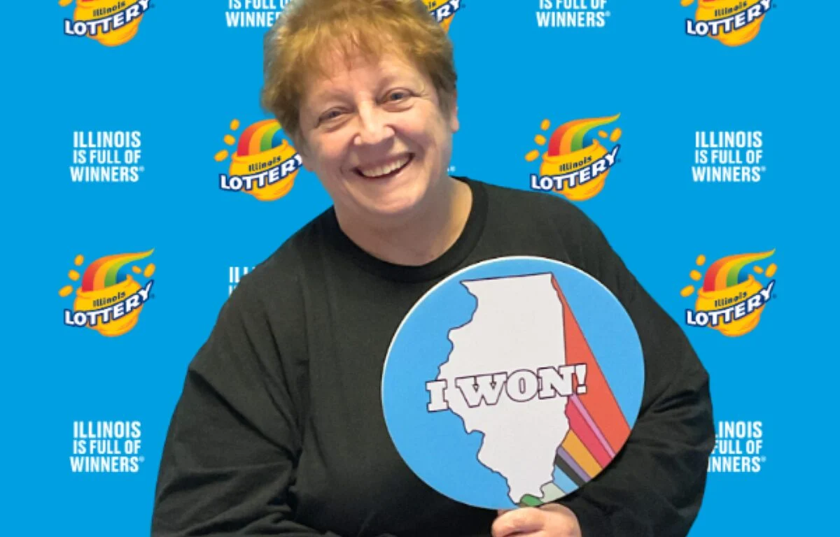 Holly of Johnston City, Illinois, celebrates with a big smile after winning a $250,000 jackpot playing the Illinois Lottery’s Magnificent Multiplier FastPlay game online.