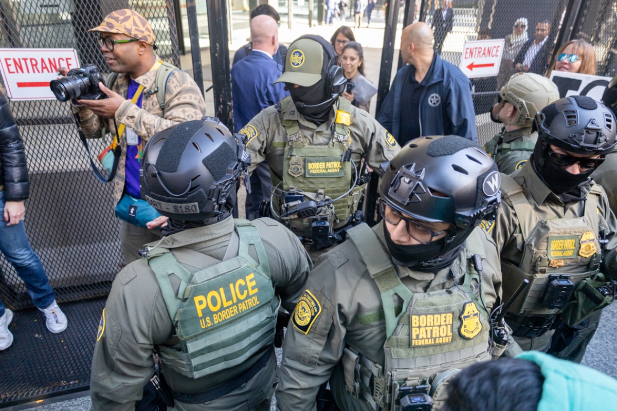 Several immigration enforcement agents push back media and protestors as U.S. Customs and Border Patrol Commander Gregory Bovino makes his way out of the federal courthouse in downtown Chicago on Oct. 28, 2025. (Capitol News Illinois photo by Andrew Adams)