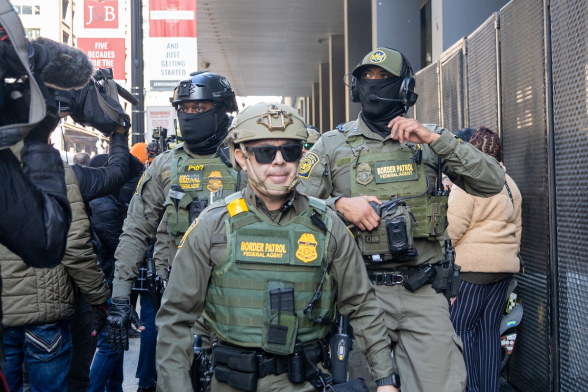 Members of the United States Border Patrol walk out of the Dirksen federal courthouse in Chicago through a sea of reporters and protesters on Oct. 28, 2025. (Capitol News Illinois photo by Andrew Adams)