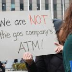 A demonstrator holds a sign reading, “We are NOT the gas company’s ATM!” at a protest held by consumer, environmental and community activists on Jan. 6, 2026. The group was criticizing Peoples Gas’ filing that sought to raise gas delivery rates in 2027. (Capitol News Illinois photo by Maggie Dougherty)