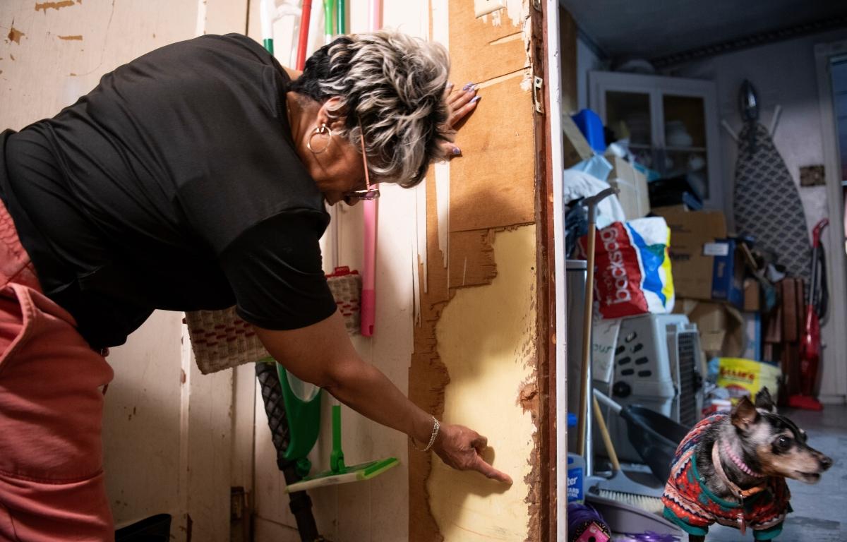 Yvette Lyles points to the spot on her wall reached by floodwaters in Cahokia Heights, Ill., May 15, 2025. (AP Photo/Michael Phillis)