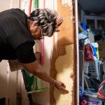 Yvette Lyles points to the spot on her wall reached by floodwaters in Cahokia Heights, Ill., May 15, 2025. (AP Photo/Michael Phillis)