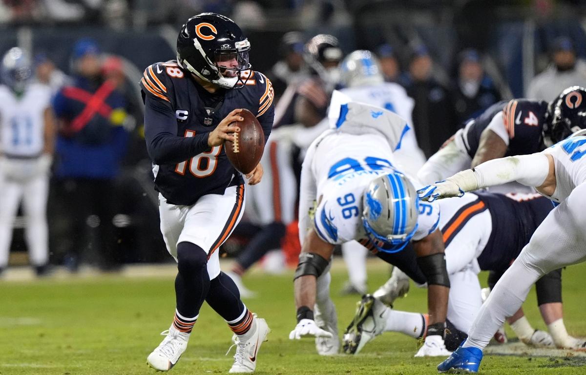 Chicago Bears quarterback Caleb Williams (18) runs from Detroit Lions linebacker al-Quadin Muhammad (96) during the second half of an NFL football game, Sunday, Jan. 4, 2026, in Chicago. (AP Photo/Nam Y. Huh)