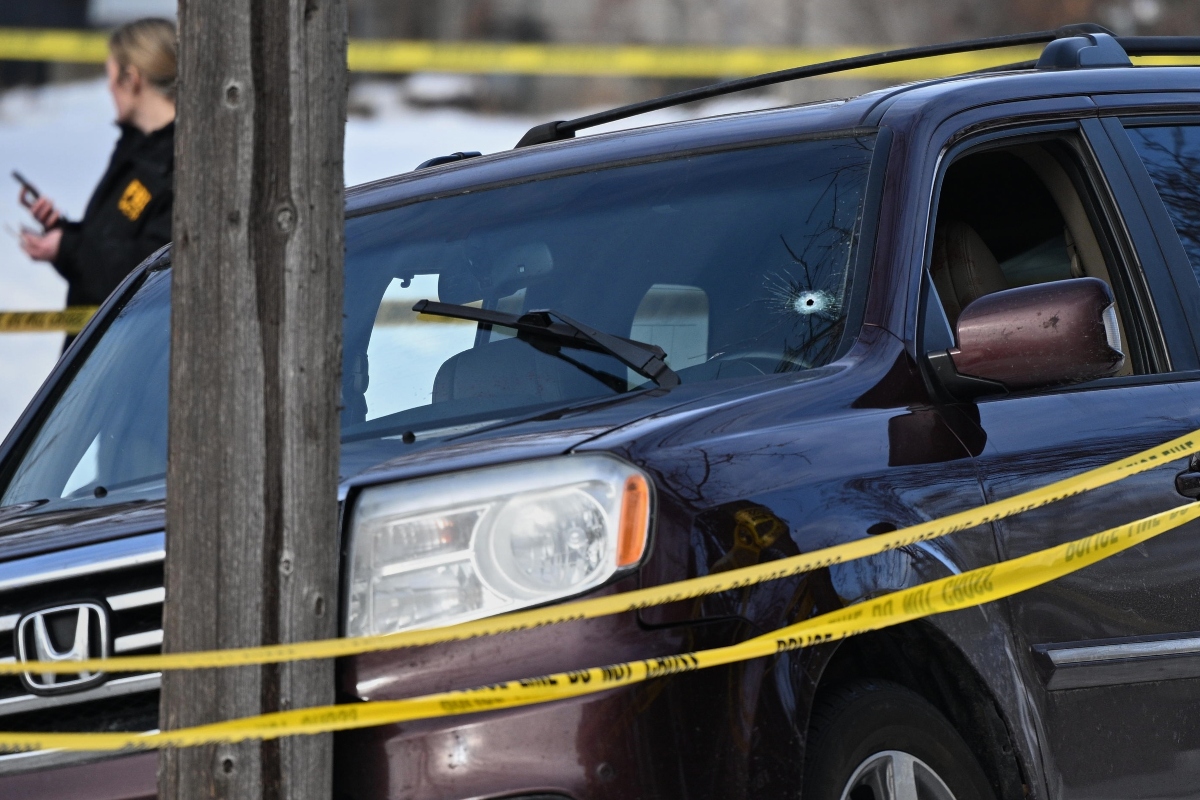 A bullet hole is seen in the windshield as law enforcement officers work at the scene of a shooting involving federal law enforcement agents, Wednesday, Jan. 7, 2026, in Minneapolis. (AP Photo/Tom Baker)