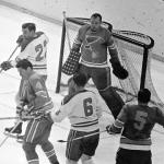 FILE - St. Louis Blues goalie Glenn Hall, top right, is pinned to his net waiting to make a save on a Montreal Canadians shot as Blues' Noel Picard (4) tries to block the puck while Canadiens' John Ferguson (22) and Ralph Backstorm wait for a rebound in the third period of their NHL hockey Stanley Cup game, May 5, 1968. (AP Photo/Fred Waters, File)