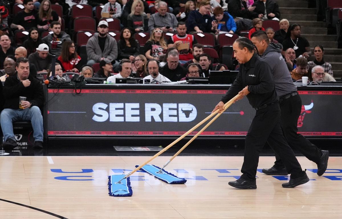 United Center employees clean the court during a delay before an NBA basketball game against the Miami Heat in Chicago, Thursday, Jan. 8, 2026. (AP Photo/Nam Y. Huh)
