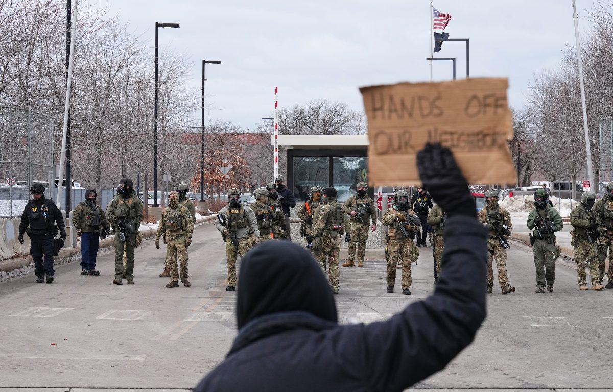 Protesters confront federal immigration officers outside the Bishop Henry Whipple Federal Building, Tuesday, Jan. 13, 2026, in Minneapolis. (AP Photo/Adam Gray)