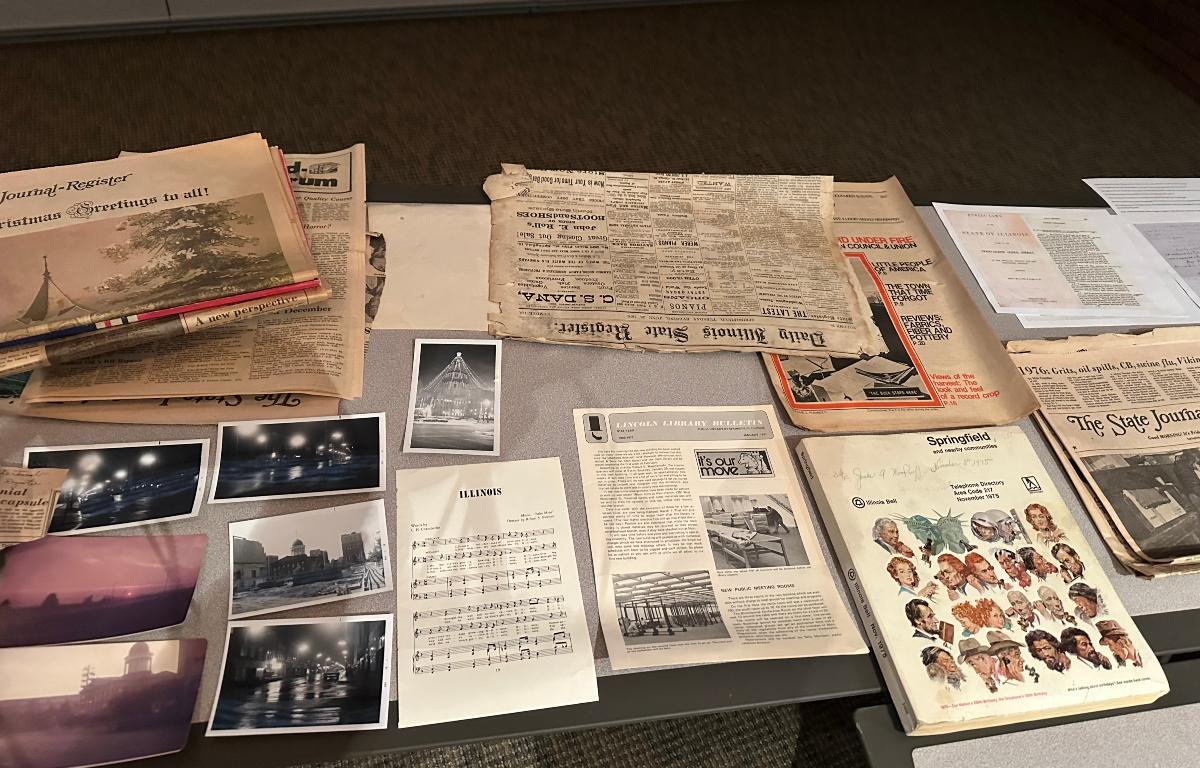 Newspapers, photographs, a phone book, and other items were in a time capsule buried in 1976, opened Monday on the occasion of the Lincoln Library's 140th birthday.