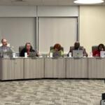 District 186 Board member Micah Miller, left, speaks during the most recent board meeting.