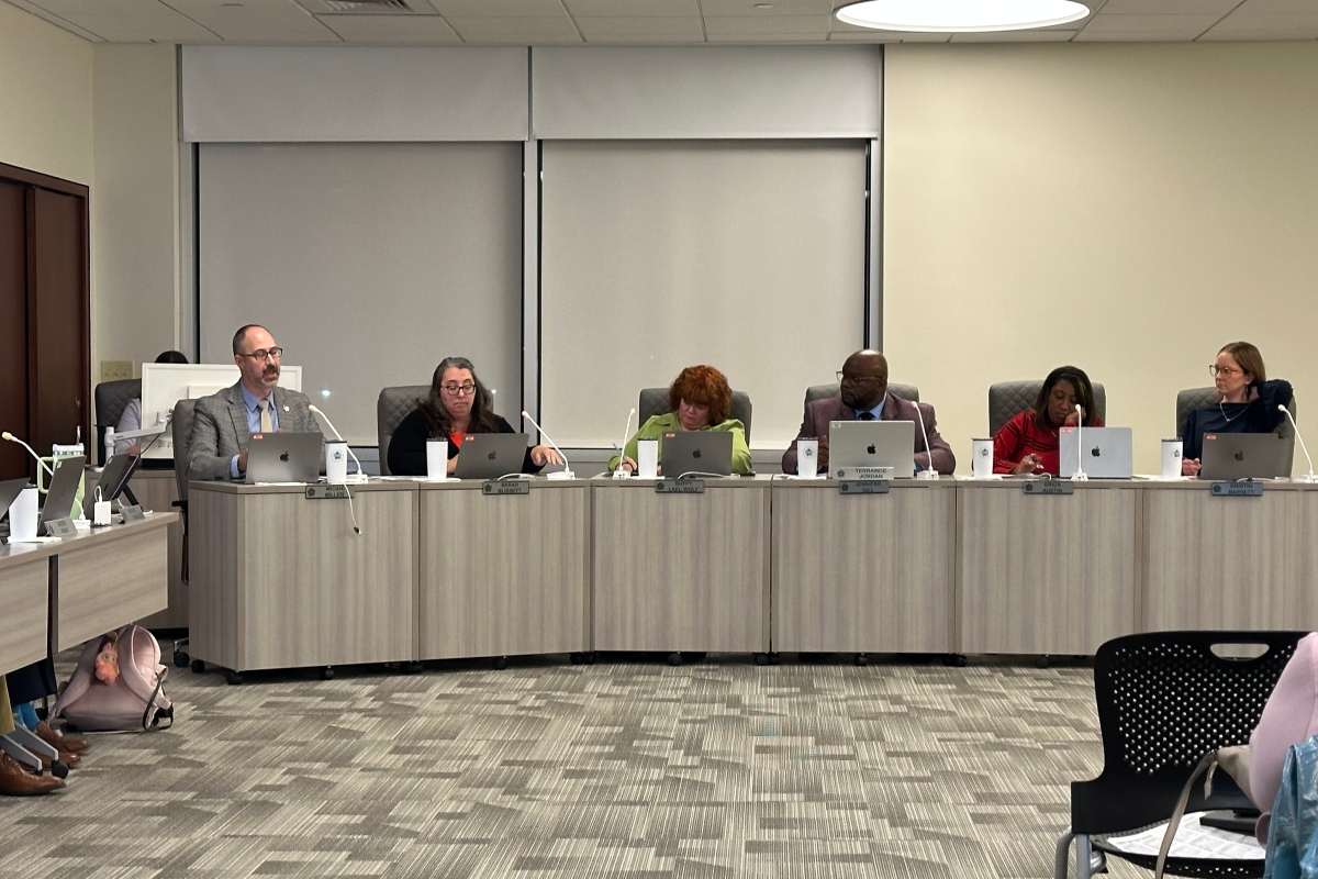 District 186 Board member Micah Miller, left, speaks during the most recent board meeting.