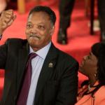 FILE - Rev. Jesse Jackson gestures to a friend in the balcony at the 16th Street Baptist Church in Birmingham, Ala., Sept. 15, 2013. The church held a ceremony honoring the memory of the four young girls who were killed by a bomb placed outside the church 50 years ago by members of the Ku Klux Klan. At right is U.S. Rep. Terri Sewell, D-Ala. (AP Photo/Dave Martin, File)