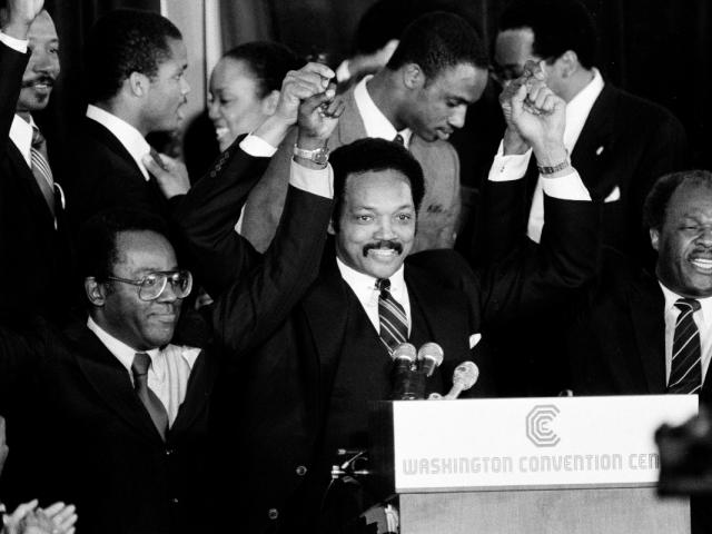 FILE - Jesse Jackson holds his hands up after announcing he will seek the Democratic nomination for president, with his campaign chairman Mayor Richard Hatcher, left, of Gary Ind., and Mayor Marion Barry of Washington, D.C., in Washington, Nov. 3, 1983. (AP Photo/Scott Stewart, File)