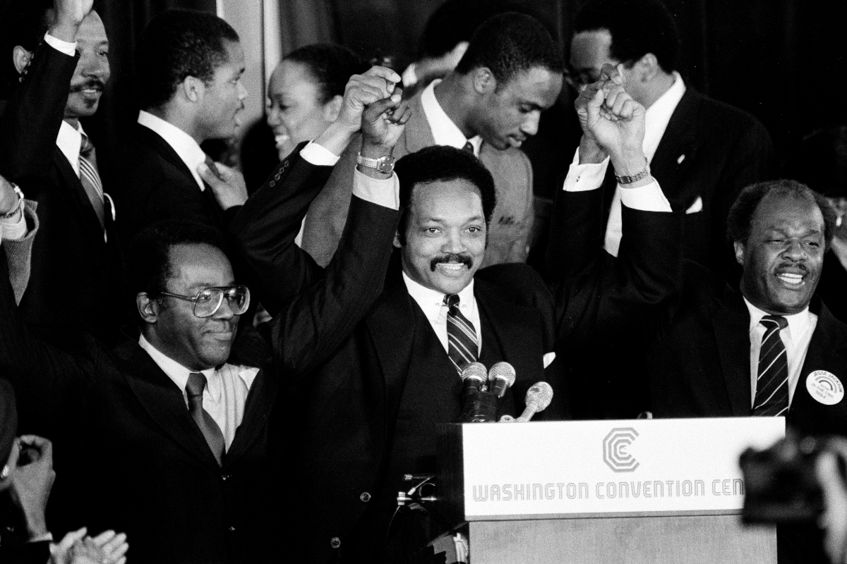FILE - Jesse Jackson holds his hands up after announcing he will seek the Democratic nomination for president, with his campaign chairman Mayor Richard Hatcher, left, of Gary Ind., and Mayor Marion Barry of Washington, D.C., in Washington, Nov. 3, 1983. (AP Photo/Scott Stewart, File)
