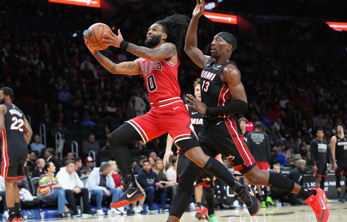 Chicago Bulls guard Coby White (0) drives to the basket as Miami Heat center Bam Adebayo (13) defends during the second half of an NBA basketball game, Sunday, Feb. 1, 2026, in Miami. (AP Photo/Lynne Sladky)